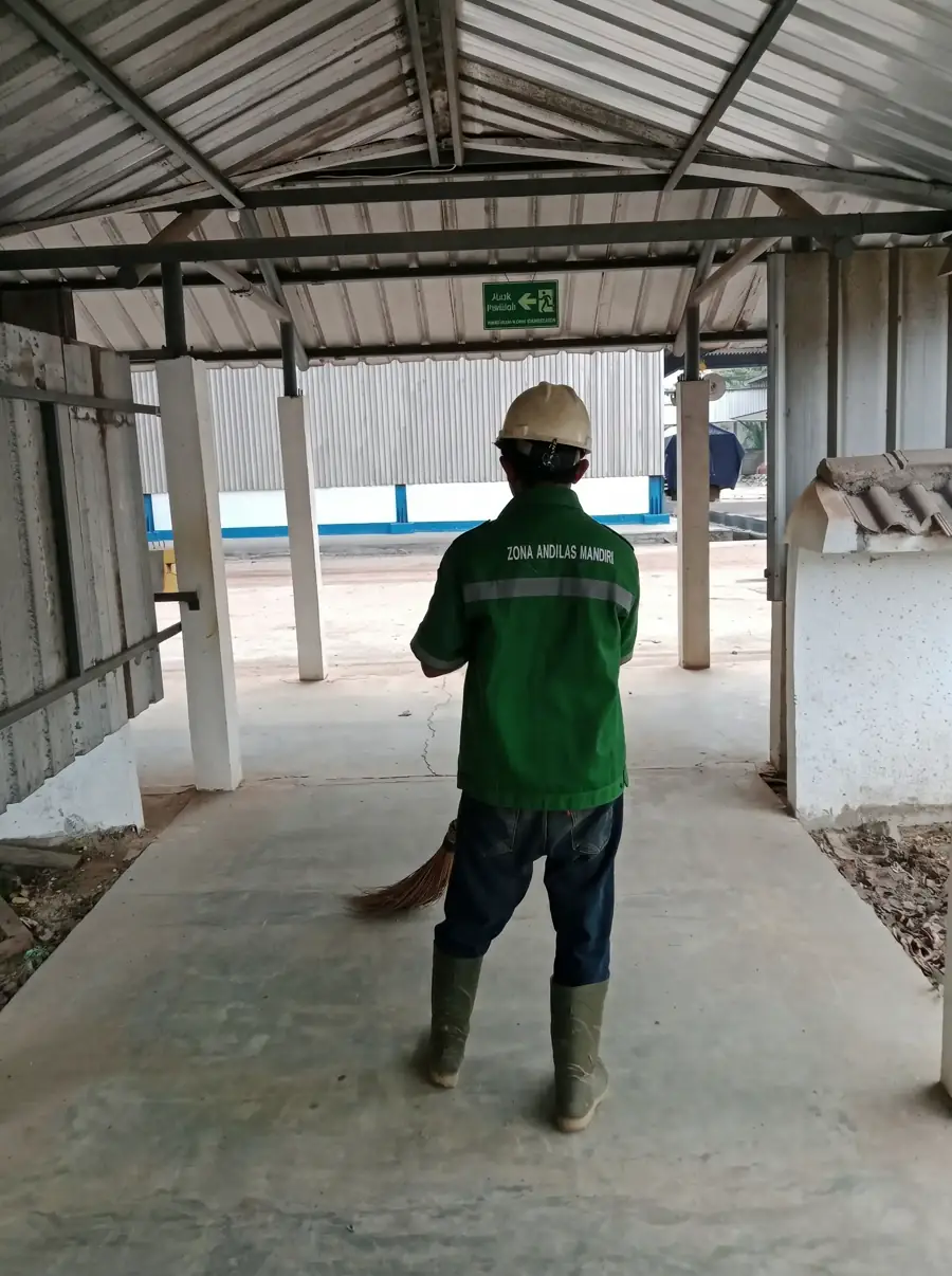 Pekerja cleaning service ZAM Lampung sedang menyapu area kerja luar ruangan